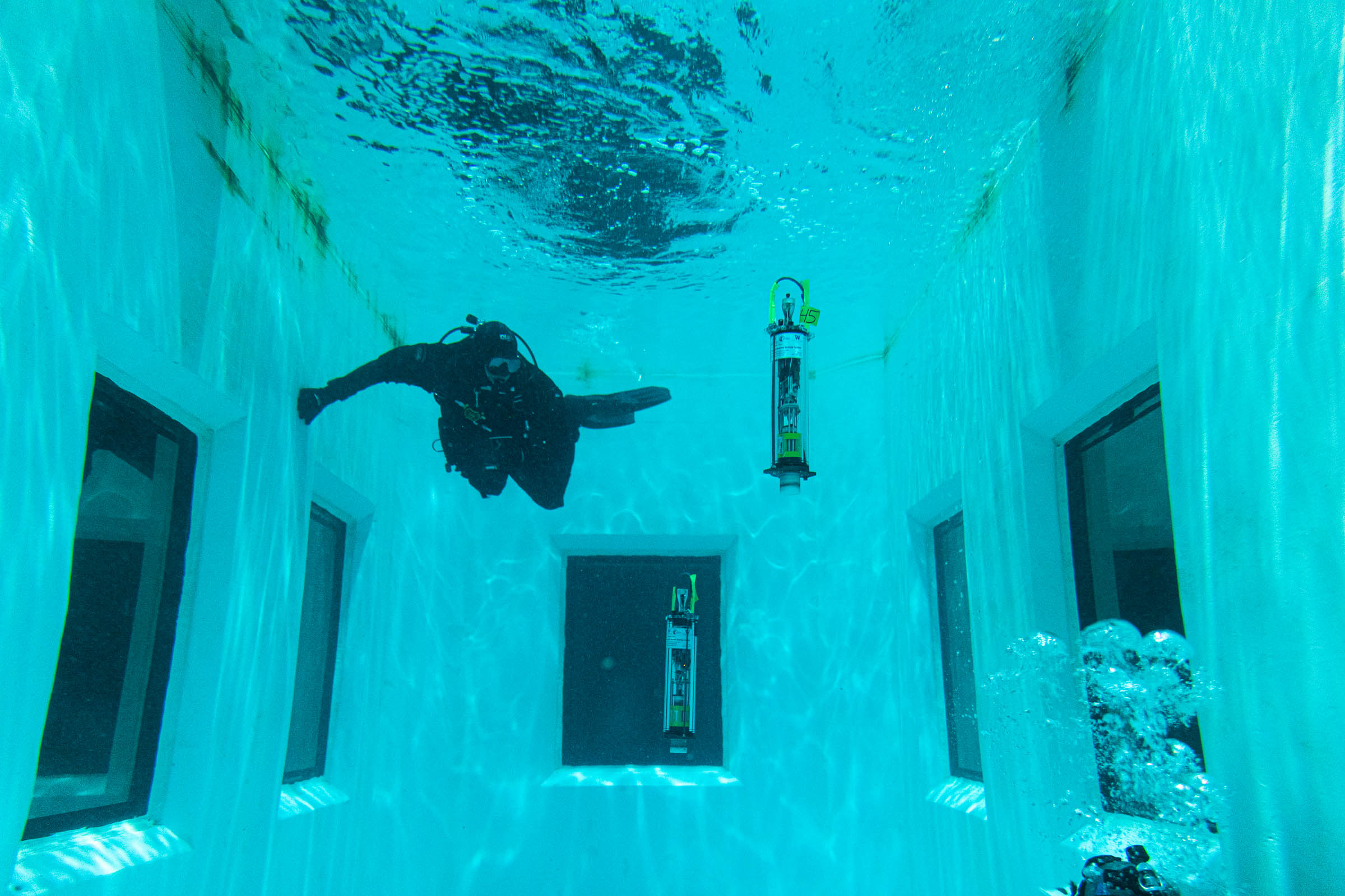 a diver in a water tank next to a floating µFloat