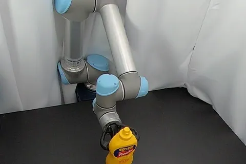 3D printed robotic gripper holding a mustard bottle 