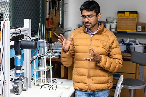 Man in a lab standing next to two machines