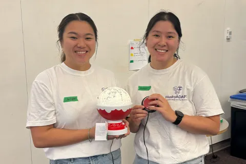 Two people posing with a toy in their hands