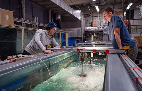 Abigale Snortland and Greg Talpey observe a cross-flow turbine in the Alice C. Tyler flume in the UW Harris Hydraulics Lab