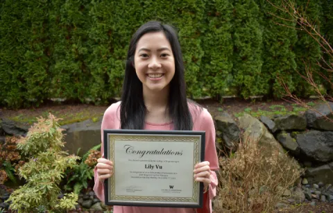 Photo of a Asian female student holding a certificate