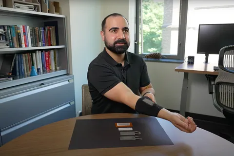 Researcher demoing a device in his arm 