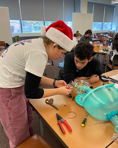 Two students are working on disassembling a toy