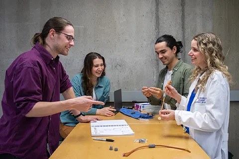 a group of people around a table working on a project together