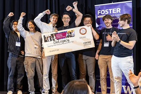 Team holding large checks and celebrating their achievements on stage.